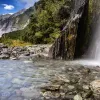 Waterfall flowing into a crystal clear river