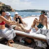Six guests on boat, three looking at one of their phones.