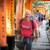 Walking up a hill among orange arches in Japan