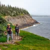 Two guests walking alongside coastal cliff.