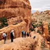 Guests hiking in national park among boulder formations