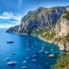 Wide shot of Amalfi Coast, boats dotting the crystal blue water.