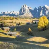 Green slopping hills in front of snowy mountains