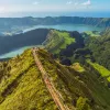 Sky view of a long path that sits on top of a long, grass-covered cliff