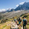 Group of hikers descending down a rocky and grassy hillside