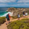 People hike down a beachfront road