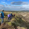 Hikers walk along a rocky mountain path
