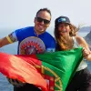 Man and woman smiling while holding up a Portugal flag