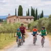 Family riding bikes on a gravel road with a brick church building in the background