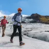 Two hikers walking through a snowy mounds on a trail