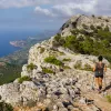 Woman with hiking poles, walking on a large mountain