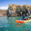 Two women laughing while paddling on a kayak