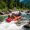 Group of people on a red raft, paddling 