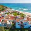 Sky view of white and brown houses next to the beach shore