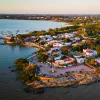 Sky view of small town by the ocean, with cars parked along the beach