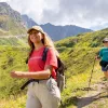 Two women smiling while walking on a dirt and grass trail