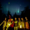 Group of people holding lanterns under the night sky
