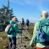 Group of people with walking poles, ascending a rocky trail