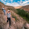 Group of women with walking poles descending a dirt trail