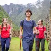 Group of men and women with walking poles, walking through stone ruins