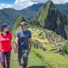 Man and women holding hands, with sights of Machu Picchu in the background