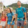 Two women and one man smiling while walking on a boat dock by the water
