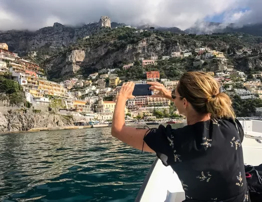 Wide shot of Positano, Amalfi Coast. Guest taking photo in foreground.
