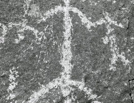 Shot of rock etching, human forms.