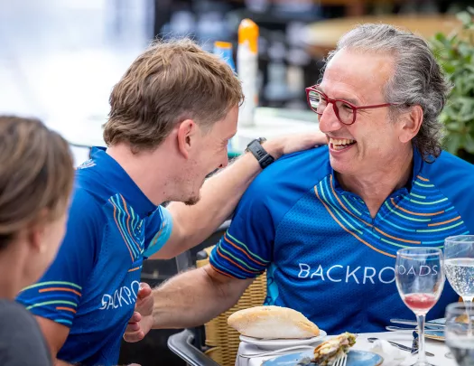 Backroads guests at a meal in their jerseys after a bike ride.