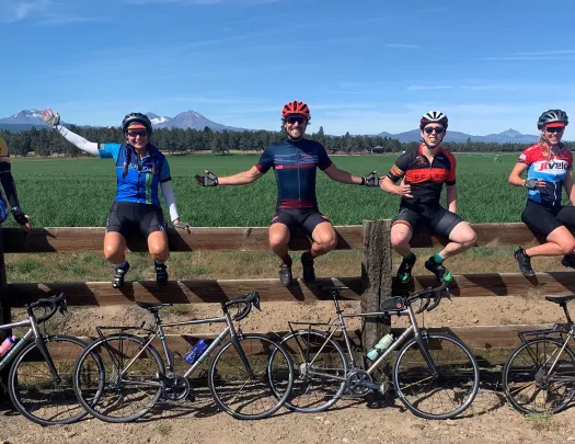 Five guests and their bikes, sitting on a large fence.