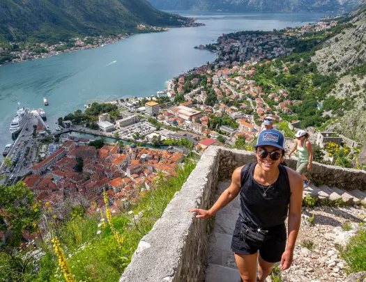 Two guests walking up stone staircase, Croatian village, river below them.