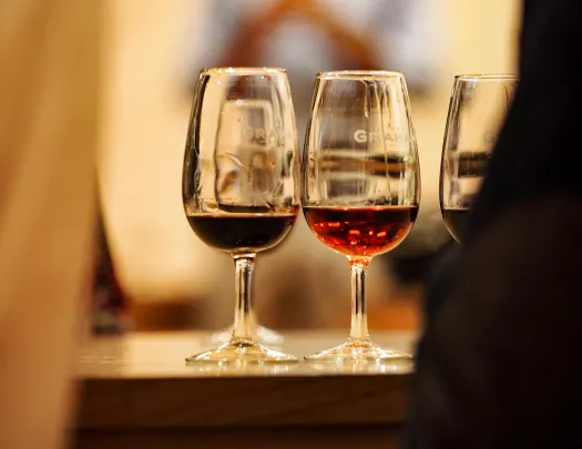 Three glasses of red wine on a table.