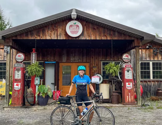 Guest with bike standing in front of "THE APPLE STATION".