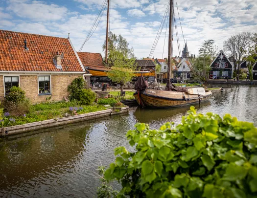Shot of small river, houses, wooden boat.