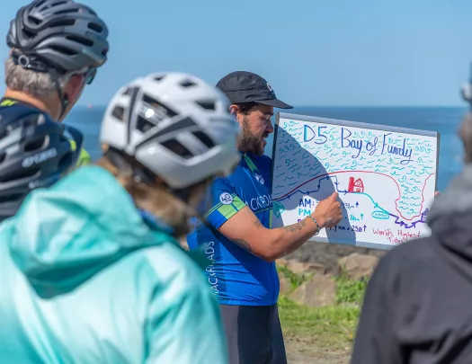 Guests receiving D5 leader brief, ocean in background.