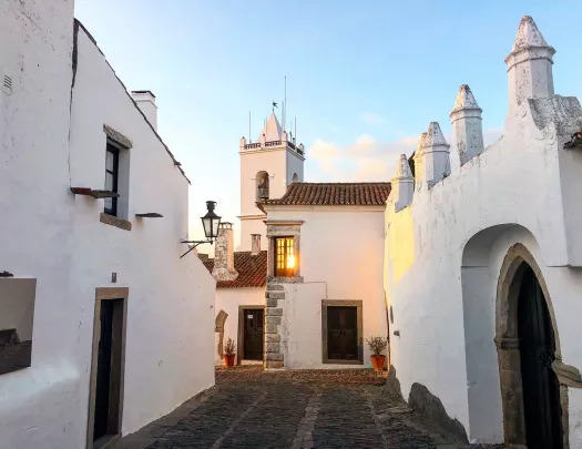 Walkway shot of white walled village during sunset.