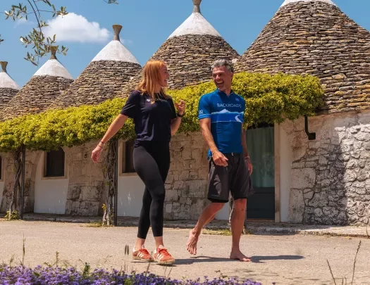 Guests hiking past conical houses of Alberobello.