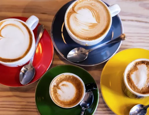 Close-up of four full coffee mugs.