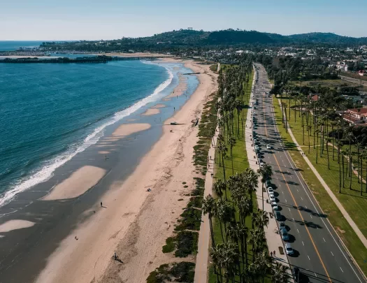 Wide shot of PCH in Santa Barbara, beach and ocean on left.