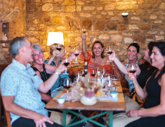 Group of guests at dinner, cheersing wine glasses.