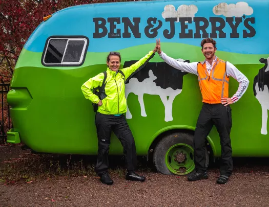 Two guests high-fiving in front of Ben & Jerry's car.