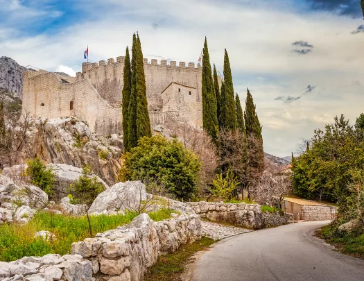 Shot of road leading to white brick castle structure. 