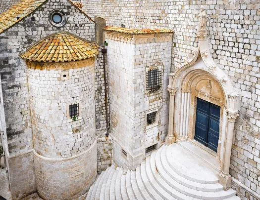 Shot of white stone buildings, staircase, doorway, etc.