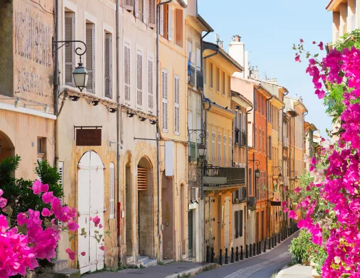 European alleyway lined with blooming bougainvillea flowers.
