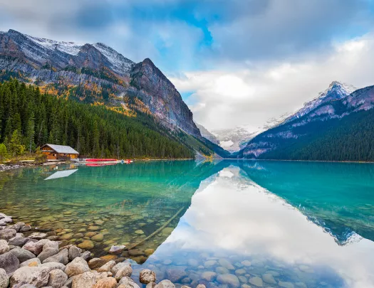 Large lake vista, wooden shack, mountains in background.