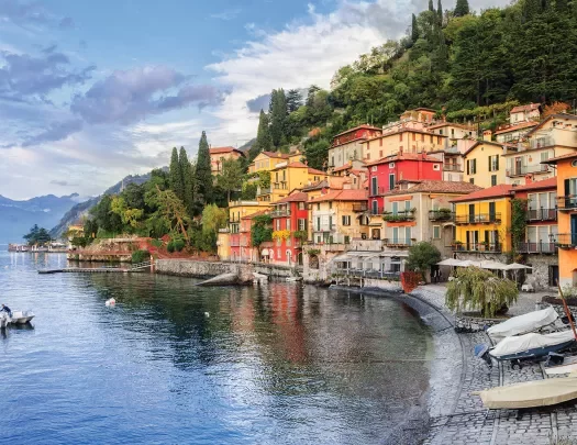 Wide shot of Lake Como coastline, colorful houses.