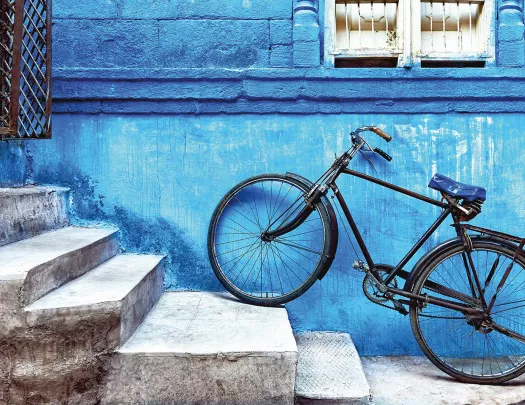 Bike sitting on the stairs against a blue wall