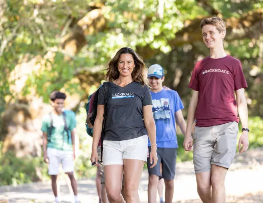 Group of guests walking on trail, one smiling at camera.