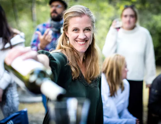 Point of view shot of woman pouring wine in a (your) glass.