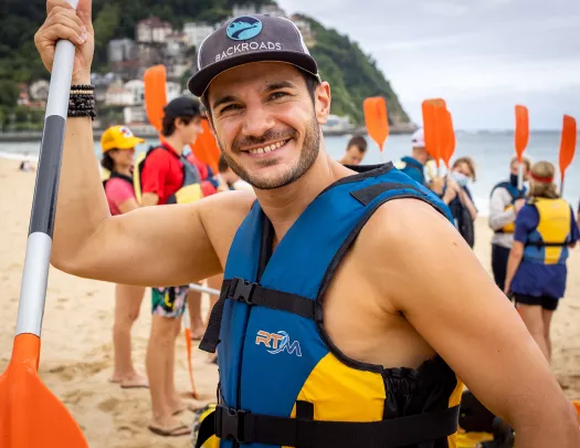 Close-up of leader in kayaking gear on beach.